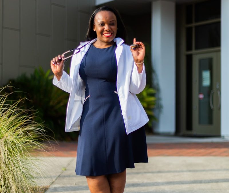 a woman in a blue dress and white jacket